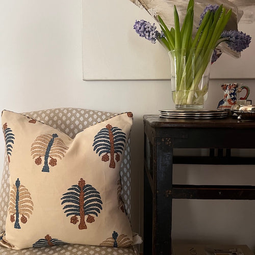 The Voyage Dubai. A charming square cushion crafted from Penny Morrison's playful Gobi Blue print linen finished with a cream and blue striped piping and concealed zip. The perfect addition to a sofa, armchair or bed.