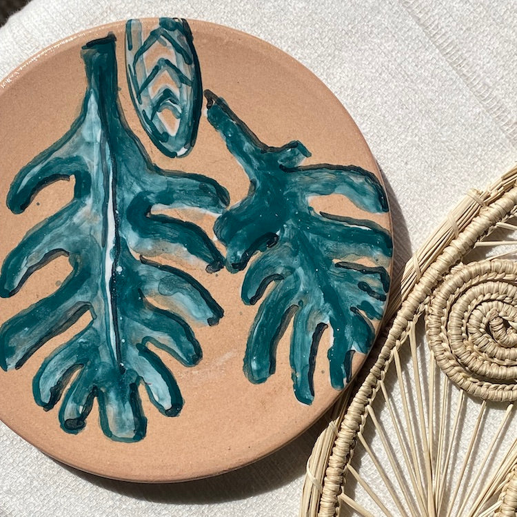 The Voyage Dubai - The Prickly Pear small saucer plate is a beautiful, hand painted piece, inspired by the Mediterranean landscape. This unique piece is an eye-catching addition to any kitchen, dining room, or living space. Use as a saucer or a lovely display piece to create an interesting vignette.