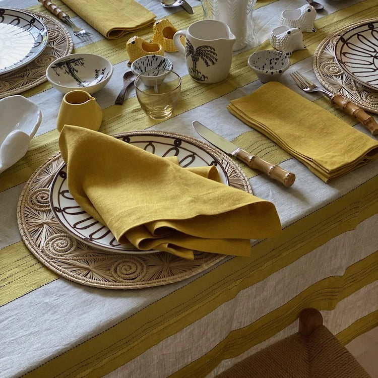 A Volga Linen tablecloth paired with TVD linen dinner napkins in ochre.