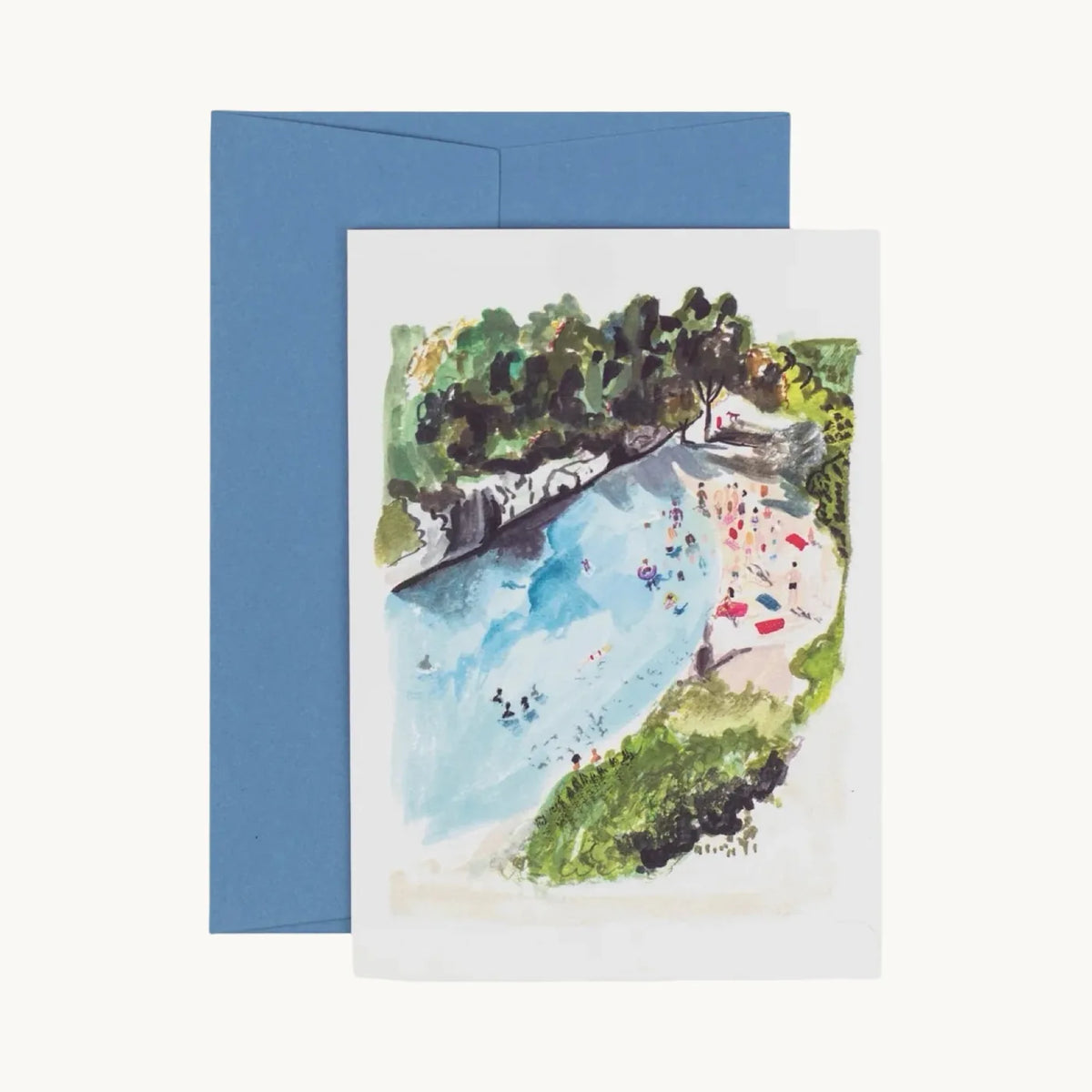 Greeting card of swimmers in a turquoise cove beside a sandy beach with towels, trees above, with a blue envelope