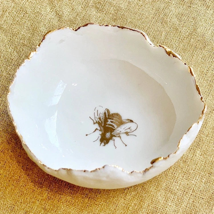 Handmade in a small studio in Notting Hill by Heidi Bishop, this stunning porcelain 'jagged' bowl features a delicate hand painted bee and is finished with gold edging.