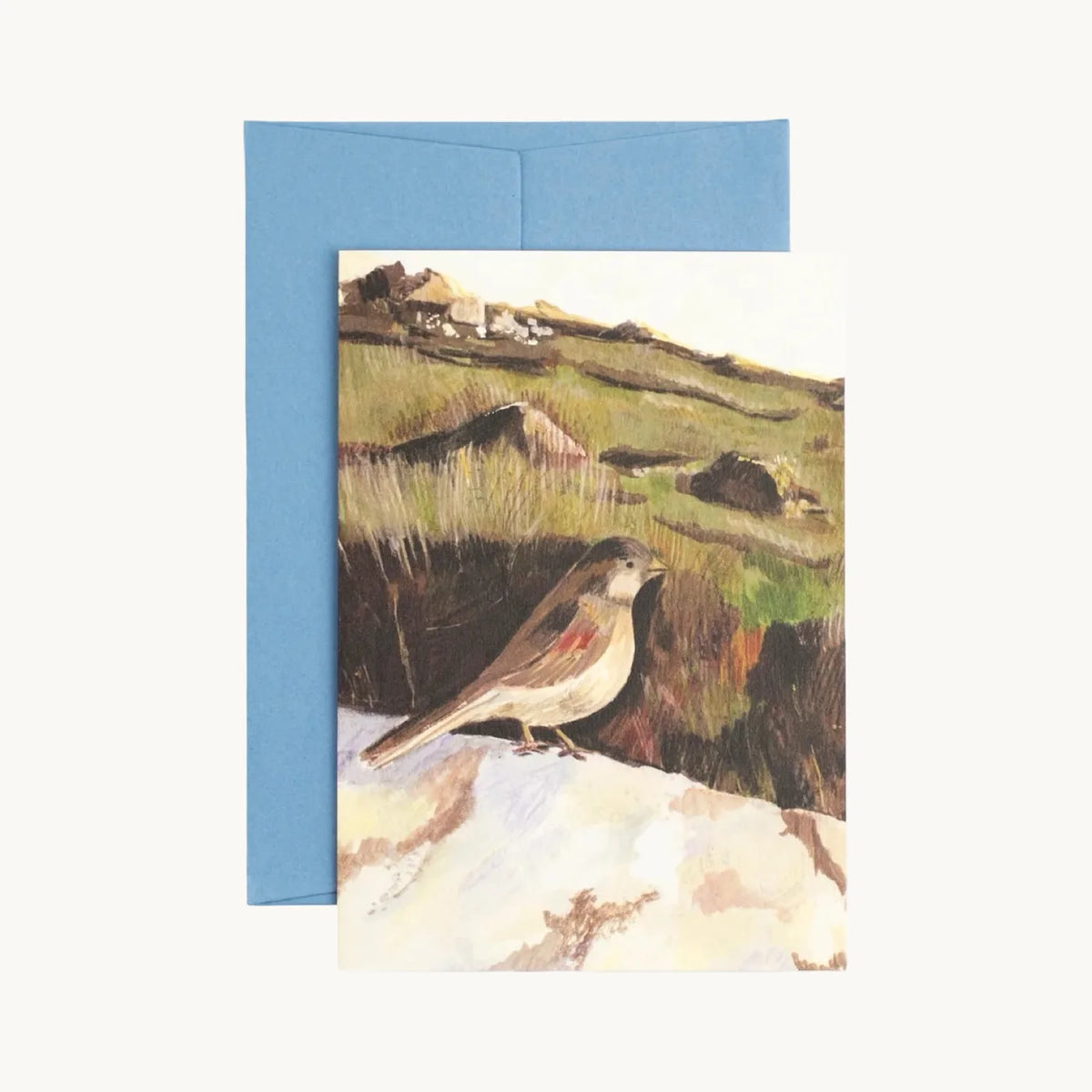 Greeting card of a small brown bird with a red wing patch perched on a pale rock above moorland grass, with a blue envelope