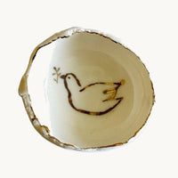 Handmade in a small studio in Notting Hill by Heidi Bishop, this stunning porcelain 'jagged' bowl features a delicate hand painted dove and is finished with gold edging.