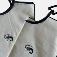 The Voyage Dubai - Adult Bibs - Designed in-house by the team at The Voyage Dubai and sewn by hand locally, these generously-sized, ultra chic adult bibs are finished with a black trim and matching or contrasting embroidery.
Sold in pairs of two. Perfect for date night.