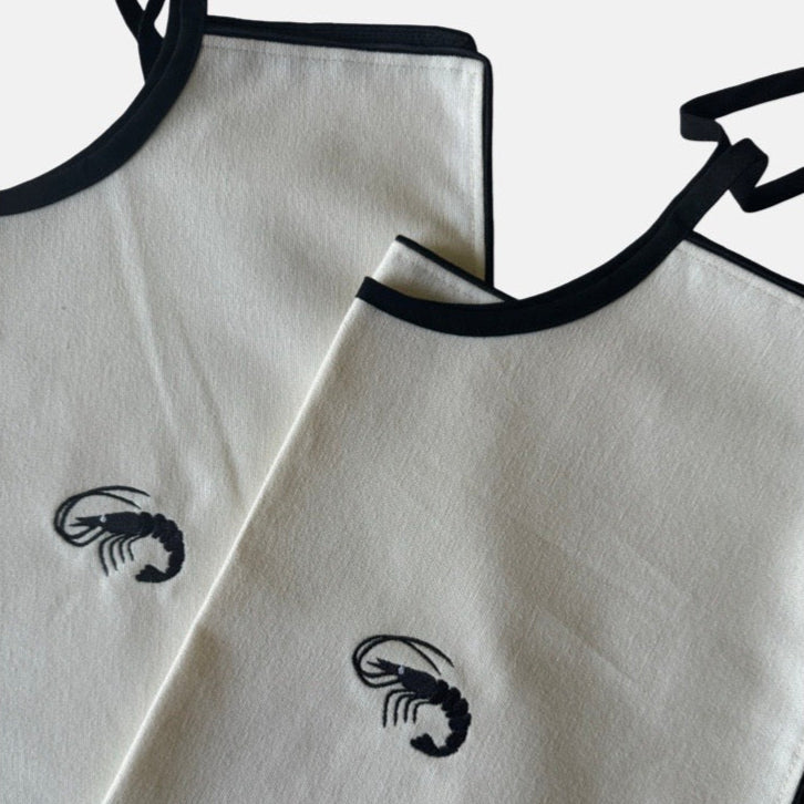 The Voyage Dubai - Adult Bibs - Designed in-house by the team at The Voyage Dubai and sewn by hand locally, these generously-sized, ultra chic adult bibs are finished with a black trim and matching or contrasting embroidery.
Sold in pairs of two. Perfect for date night.