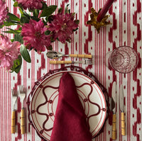 The Voyage Dubai - Mallorcan Ikat Tablecloth in Raspberry Ribbon. A striking cotton blend tablecloth printed in this traditional geometric motif reflective of the easy Mediterranean lifestyle. Perfect for long lunches and alfresco dining.