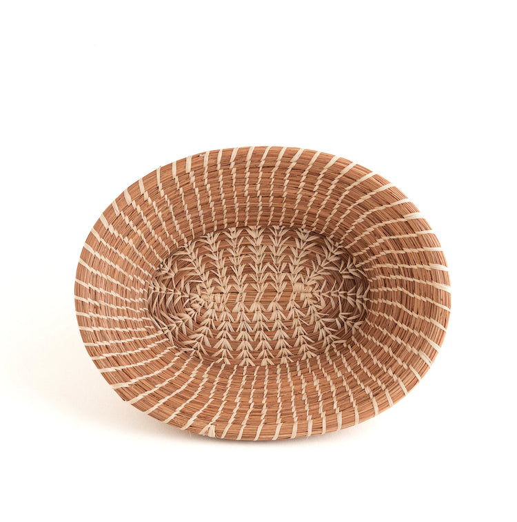 Handmade by skilled artisans in Guatemala, the Rosa basket is delicately handwoven from native grass and pine needles with raffia accents. Functional as well as beautiful, the Rosa is perfect as a bread basket or decorative piece.  Handmade and fair trade.