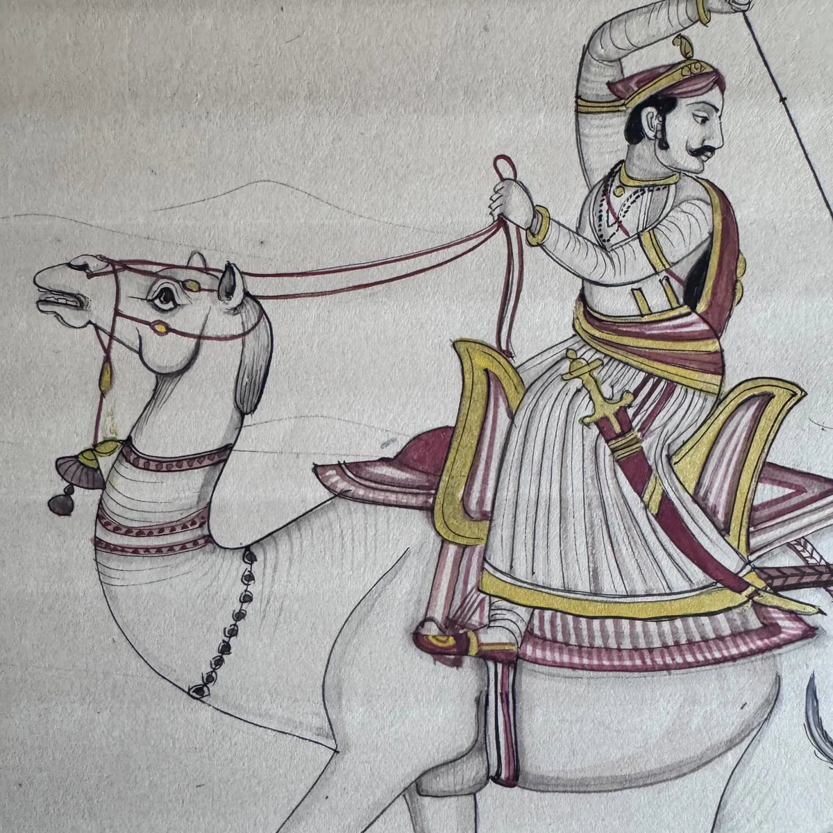 Detail of a Maharaja riding a galloping camel, drawn with gold and maroon on the rider, on old paper