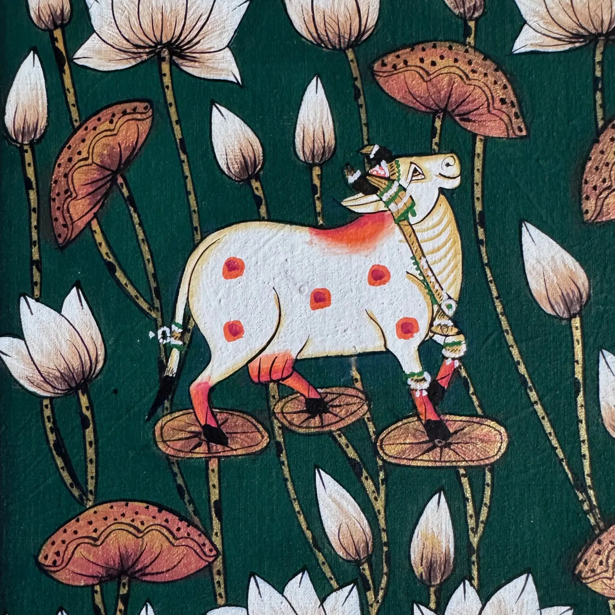 Original painting on cloth of a white cow with orange spots standing among lotus flowers, buds and leaves on a deep green ground