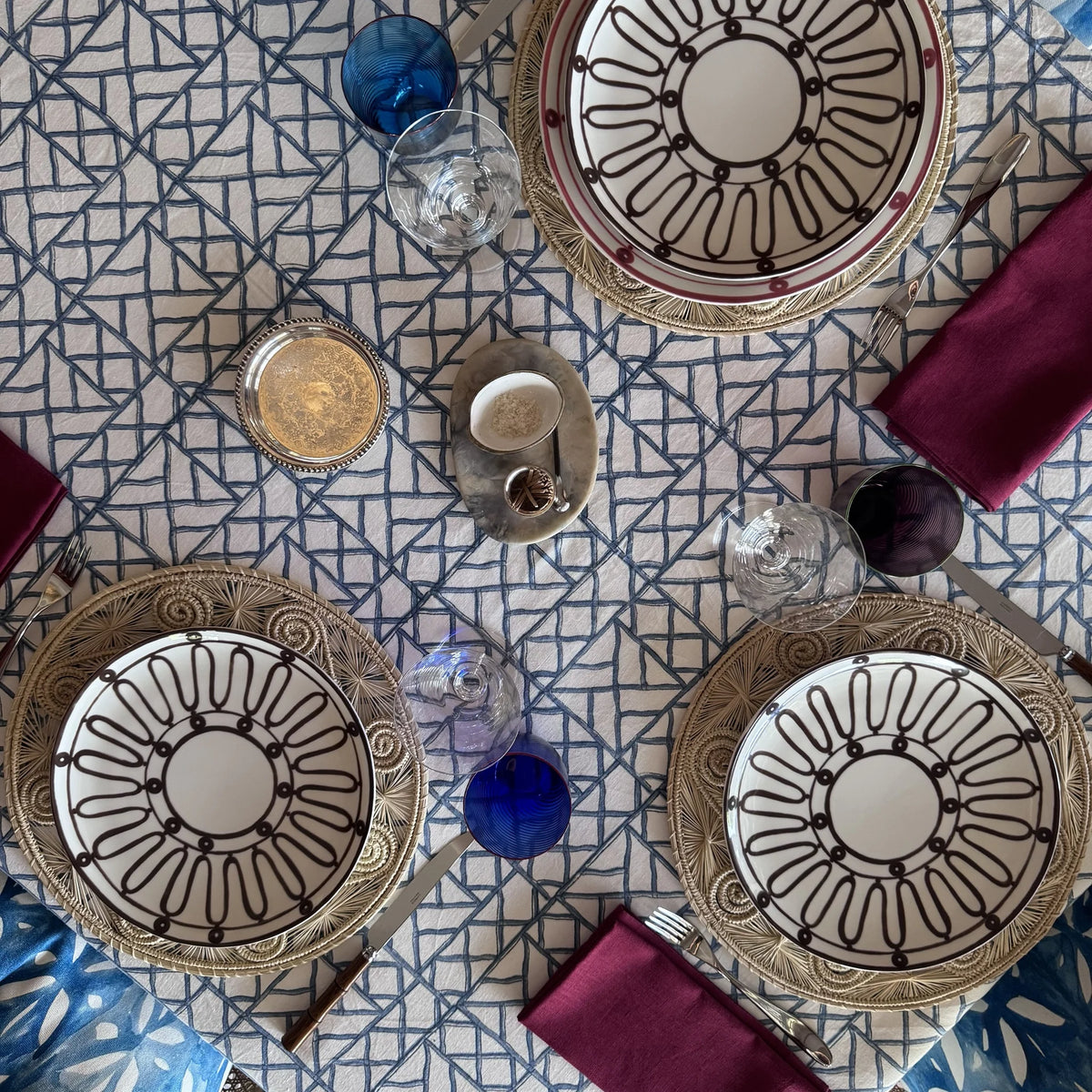 (07) Blue Pagoda tablecloth with the blue lattice running on the diagonal, set for three with rattan chargers and burgundy napkins