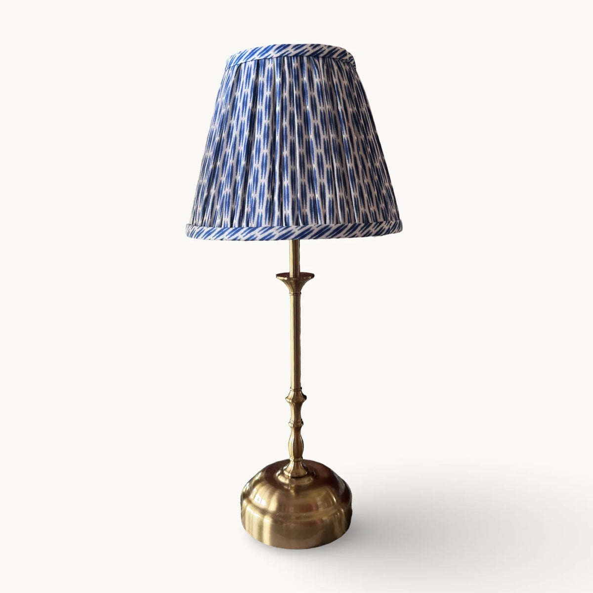 The Voyage Dubai - Cordless Antique Gold Table Lamp with Blue Ikat Shade - Rechargeable iron table lamp. Front view on a cream background.