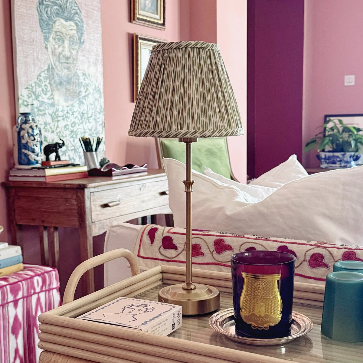 The Voyage Dubai - Cordless Antique Gold Table Lamp with Green Ikat Shade - Rechargeable iron and acrylic table lamp. Styled on a rattan tray beside a candle.