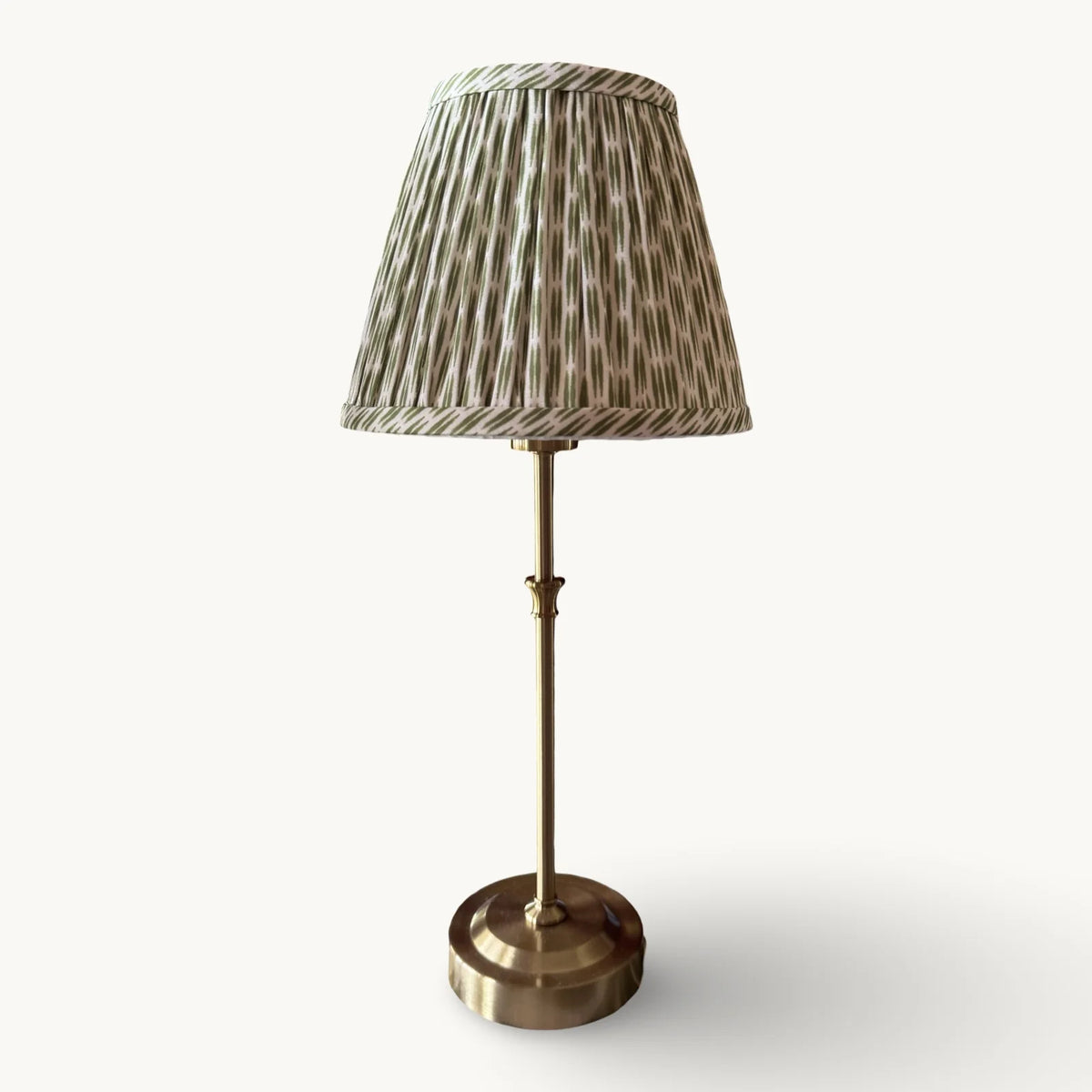 The Voyage Dubai - Cordless Antique Gold Table Lamp with Green Ikat Shade - Rechargeable iron and acrylic table lamp. Front view on a cream background.