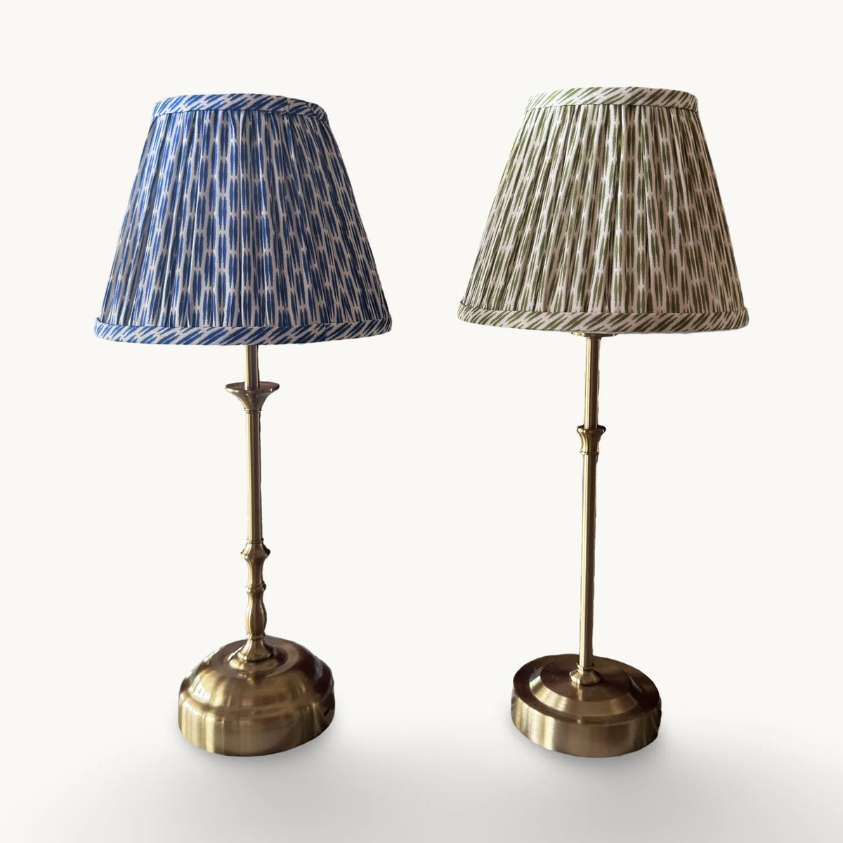 The Voyage Dubai - Cordless Antique Gold Table Lamp with Green Ikat Shade - Rechargeable iron and acrylic table lamp. Shown beside the blue ikat shade version on a cream background.