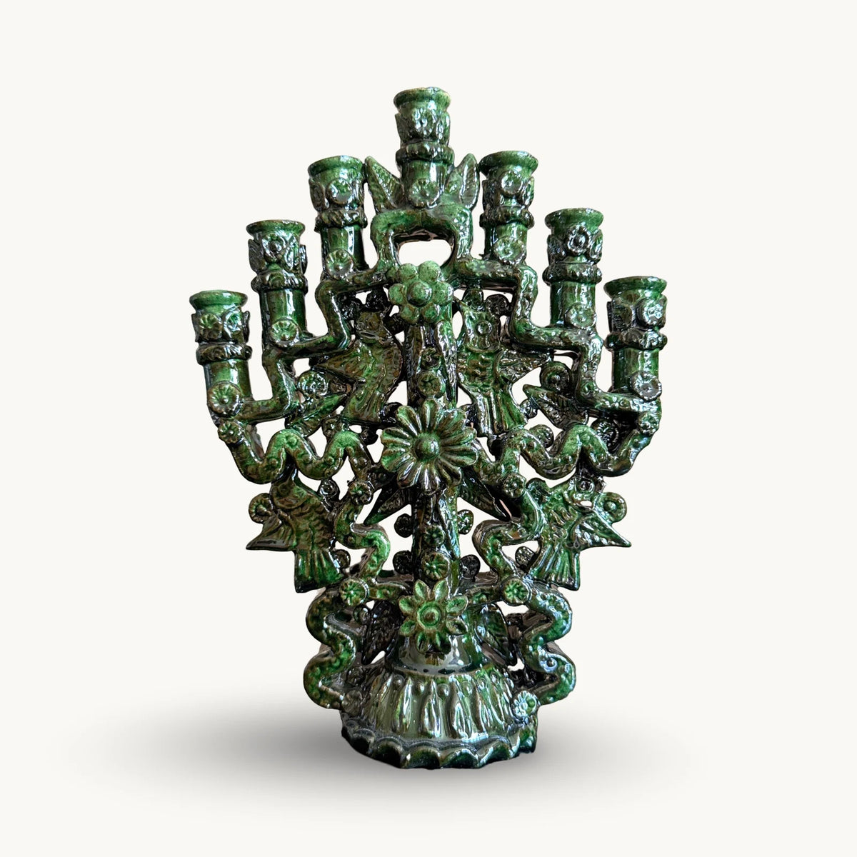 Green glazed candelabra with seven candle cups, birds, flowers and ribbon-like arms on a scalloped base