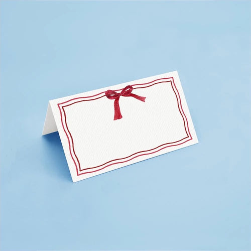 The Voyage Dubai - Christmas Bow Place Cards by Aquarela  Originally illustrated in watercolour by Portuguese artist India who draws inspiration from her home in Comporta and summers spent in the Bahamas.  Printed on luxury 200gsm textured paper.  Size: 10cm x 8cm   Sold in packs of twelve.