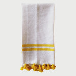 The Voyage Dubai - Made in Tangier Jibli Hand Towel - Yellow  Hand woven in Morocco from 100% pure cotton, the Jibli Hand Towel in double stripe is a great way to add a pop of colour to a guest bathroom, drinks cart or kitchen. The towels are finished with a fringe of pom poms and are made from a wonderfully soft yet highly durable handwoven cotton, making them perfect for everyday use. 