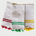 The Voyage Dubai - Made in Tangier Jibli Hand Towel - Yellow  Hand woven in Morocco from 100% pure cotton, the Jibli Hand Towel in double stripe is a great way to add a pop of colour to a guest bathroom, drinks cart or kitchen. The towels are finished with a fringe of pom poms and are made from a wonderfully soft yet highly durable handwoven cotton, making them perfect for everyday use. 