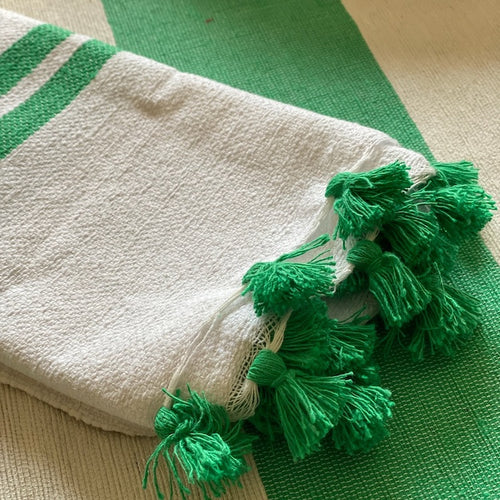 The Voyage Dubai - Made in Tangier Set of 6 Jibli Napkins - Emerald Green Inspired by the Jibli (country) women of Northern Morocco these generously sized table napkins add an element of fun to any table. Available in pure white cotton, as well as fun colourful stripes on a creamy white base, each napkin is finished with matching pom poms. Use as table napkins, tea towels or hand towels.