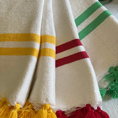 The Voyage Dubai - Made in Tangier Jibli Hand Towel - Green  Hand woven in Morocco from 100% pure cotton, the Jibli Hand Towel in double stripe is a great way to add a pop of colour to a guest bathroom, drinks cart or kitchen. The towels are finished with a fringe of pom poms and are made from a wonderfully soft yet highly durable handwoven cotton, making them perfect for everyday use.   Use as table napkins, tea towels or hand towels.