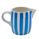 The Voyage Dubai - Milk Jug in Light Blue Stripes  Handmade and hand painted in Malta in contemporary thick stripes, designed to complement the rest of the Villa Bologna collection. The chunky bands of colour are as brilliant on their own as they are when paired with the scroll pattern and/or the Palm pieces.  Use as a milk jug or to serve sauces, dressings and gravy and create an informal setting that’s pure perfection. A useful addition to any table or kitchen, and perfect for gifting.