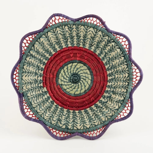 The Voyage Dubai. Handmade by skilled artisans in Sololá, Guatemala, the Josefina basket is delicately handwoven from native grass and pine needles with colourful raffia accents and a scalloped rim. Functional as well as beautiful, the basket makes a wonderful wall or tabletop accent.  Handmade and fair trade.  Origin – Guatemala  Material - native grass, pine needles, raffia  Approximate Dimensions: 11" diameter x 2.25" high