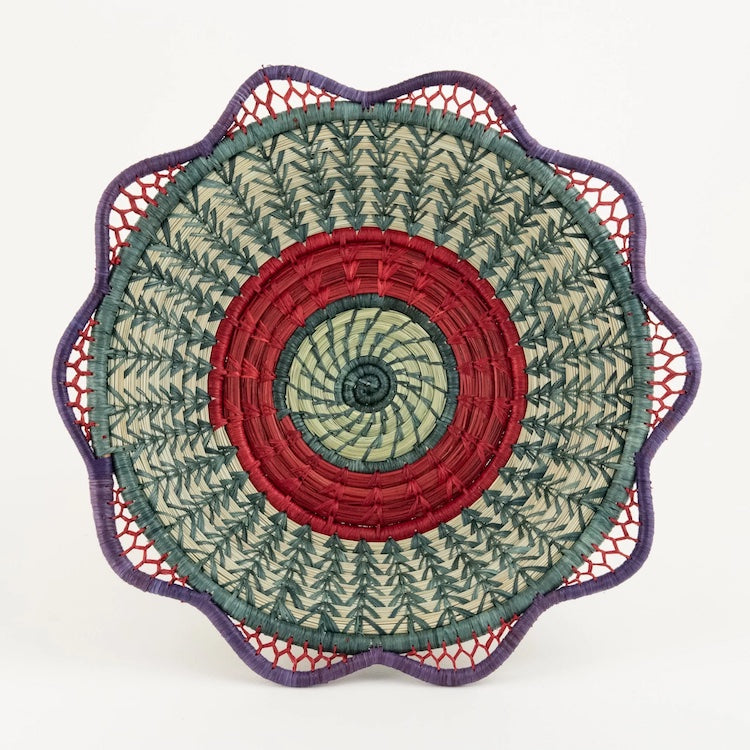 The Voyage Dubai. Handmade by skilled artisans in Sololá, Guatemala, the Josefina basket is delicately handwoven from native grass and pine needles with colourful raffia accents and a scalloped rim. Functional as well as beautiful, the basket makes a wonderful wall or tabletop accent.  Handmade and fair trade.  Origin – Guatemala  Material - native grass, pine needles, raffia  Approximate Dimensions: 11" diameter x 2.25" high