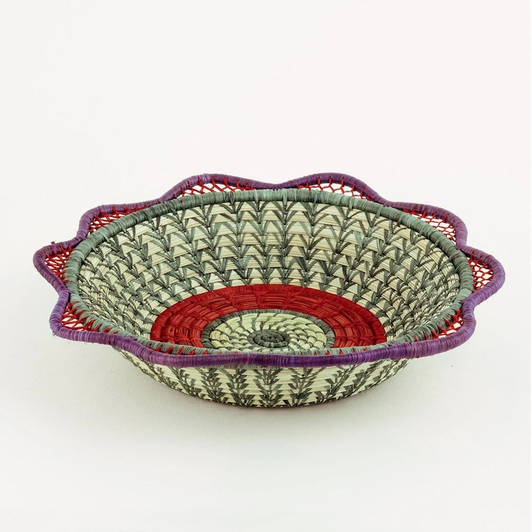 The Voyage Dubai. Handmade by skilled artisans in Sololá, Guatemala, the Josefina basket is delicately handwoven from native grass and pine needles with colourful raffia accents and a scalloped rim. Functional as well as beautiful, the basket makes a wonderful wall or tabletop accent.  Handmade and fair trade.  Origin – Guatemala  Material - native grass, pine needles, raffia  Approximate Dimensions: 11" diameter x 2.25" high