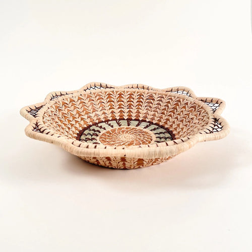 The Voyage Dubai. Handmade by skilled artisans in Sololá, Guatemala, the Catarina basket is delicately handwoven from native grass and pine needles with raffia accents. Functional as well as beautiful, the basket makes a wonderful wall or tabletop accent.  Handmade and fair trade.  Origin – Guatemala  Material - native grass, pine needles, raffia  Approximate Dimensions: 11" diameter x 2.25" high