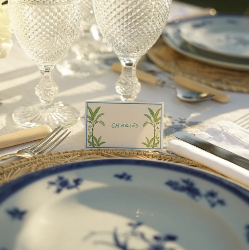 The Voyage Dubai - Green Palms Place Cards by Aquarela Originally illustrated in watercolour by Portuguese artist India who draws inspiration from her home in Comporta and summers spent in the Bahamas. Printed on luxury 200gsm textured paper. Size: 10cm x 8cm Sold in packs of twelve.