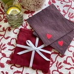 The Voyage Dubai - Seeing Hearts Cocktail Napkins in Plum (Set of 4) - A plum and red pairing with beautifully embroidered heart motifs. Great for any season, perfect for Valentine's -  Our cocktail napkins are handcrafted from 100% European linen that has been stonewashed and softened giving them a wonderful, luxurious feel. 